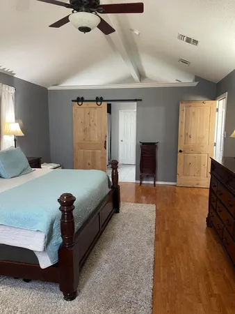 a bedroom with a bed and wooden floor