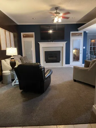 a living room with furniture a flat screen tv and a fireplace