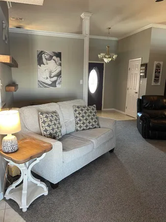 a living room with furniture and a painting on the wall