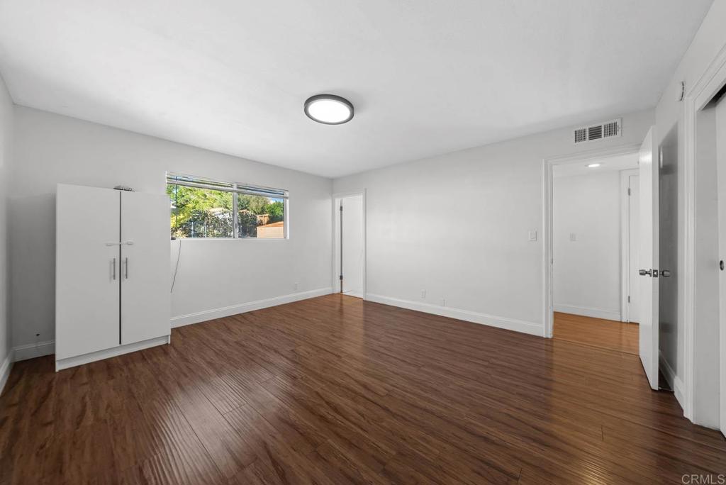 10981 Santa Cruz Road Desert Hot Springs, CA 92240 - Photo 15 of 43 an empty room with wooden floor and windows