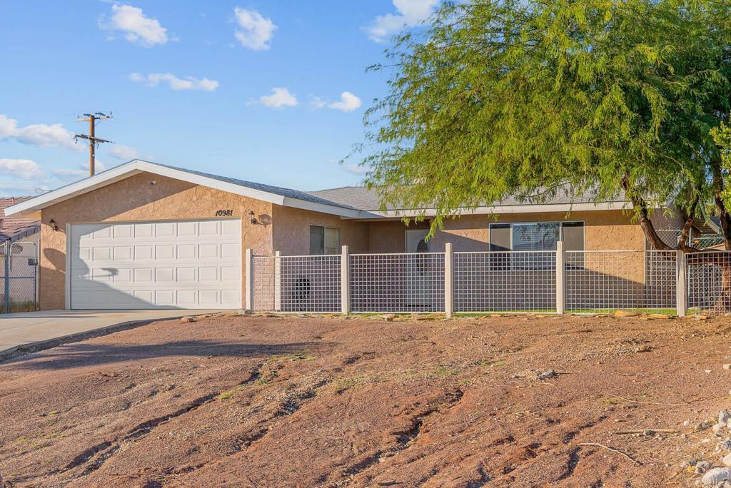 10981 Santa Cruz Road Desert Hot Springs, CA 92240 - Photo 26 of 43 a front view of a house with a yard and garage