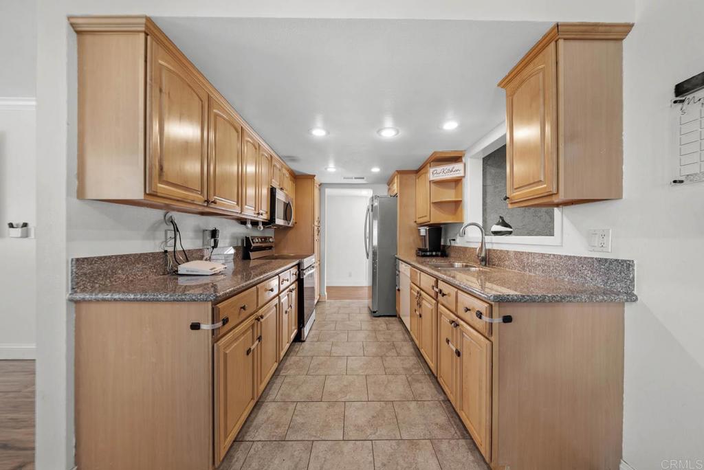 10981 Santa Cruz Road Desert Hot Springs, CA 92240 - Photo 5 of 43 a large kitchen with stainless steel appliances granite countertop a sink a stove and cabinets