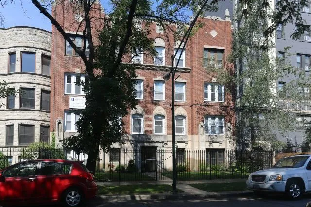 a front view of a residential apartment building with a yard