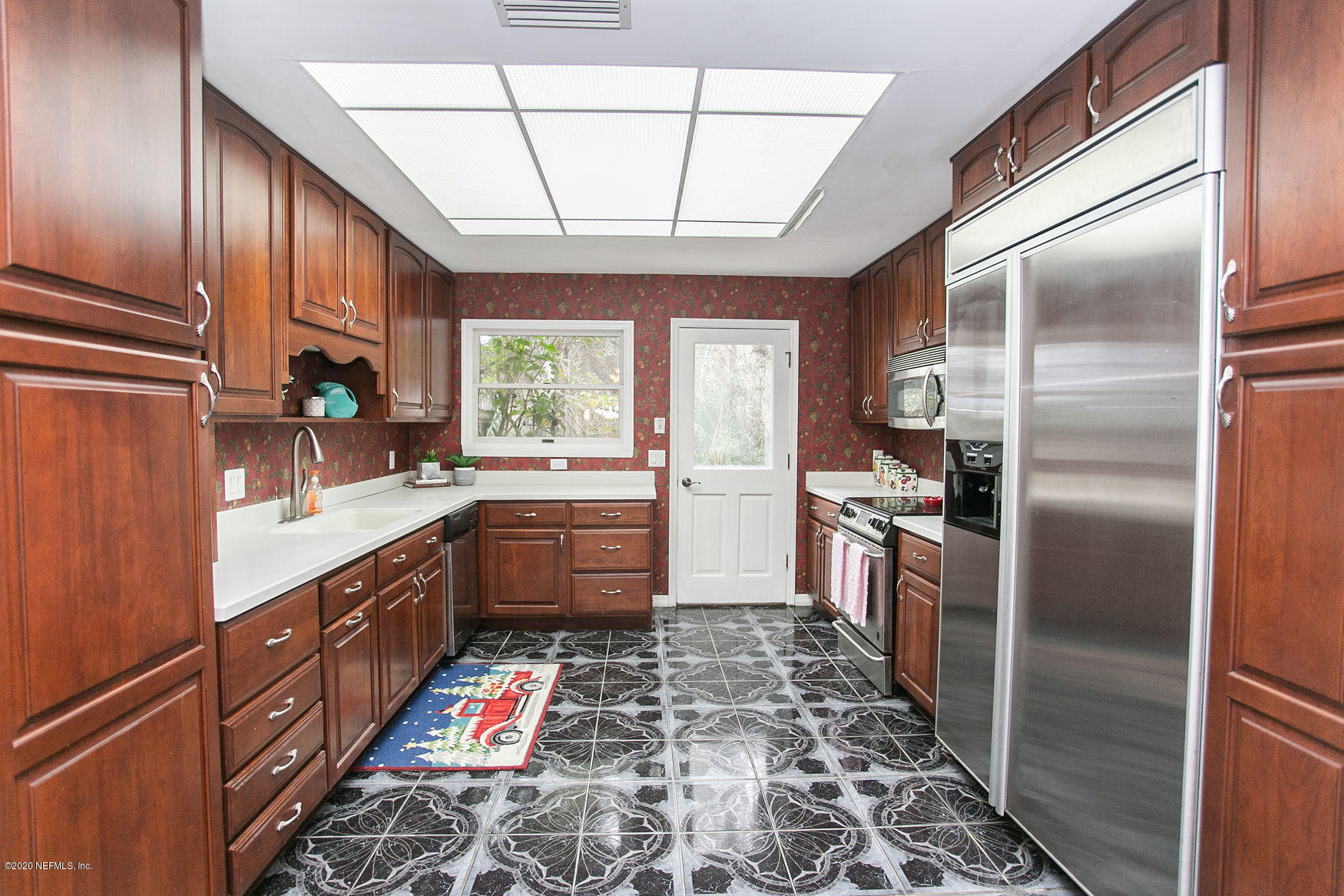 6317 Salado Road St. Augustine, FL 32080 - Photo 15 of 51 a kitchen with stainless steel appliances granite countertop a refrigerator a sink dishwasher a stove and a dining table with wooden floor