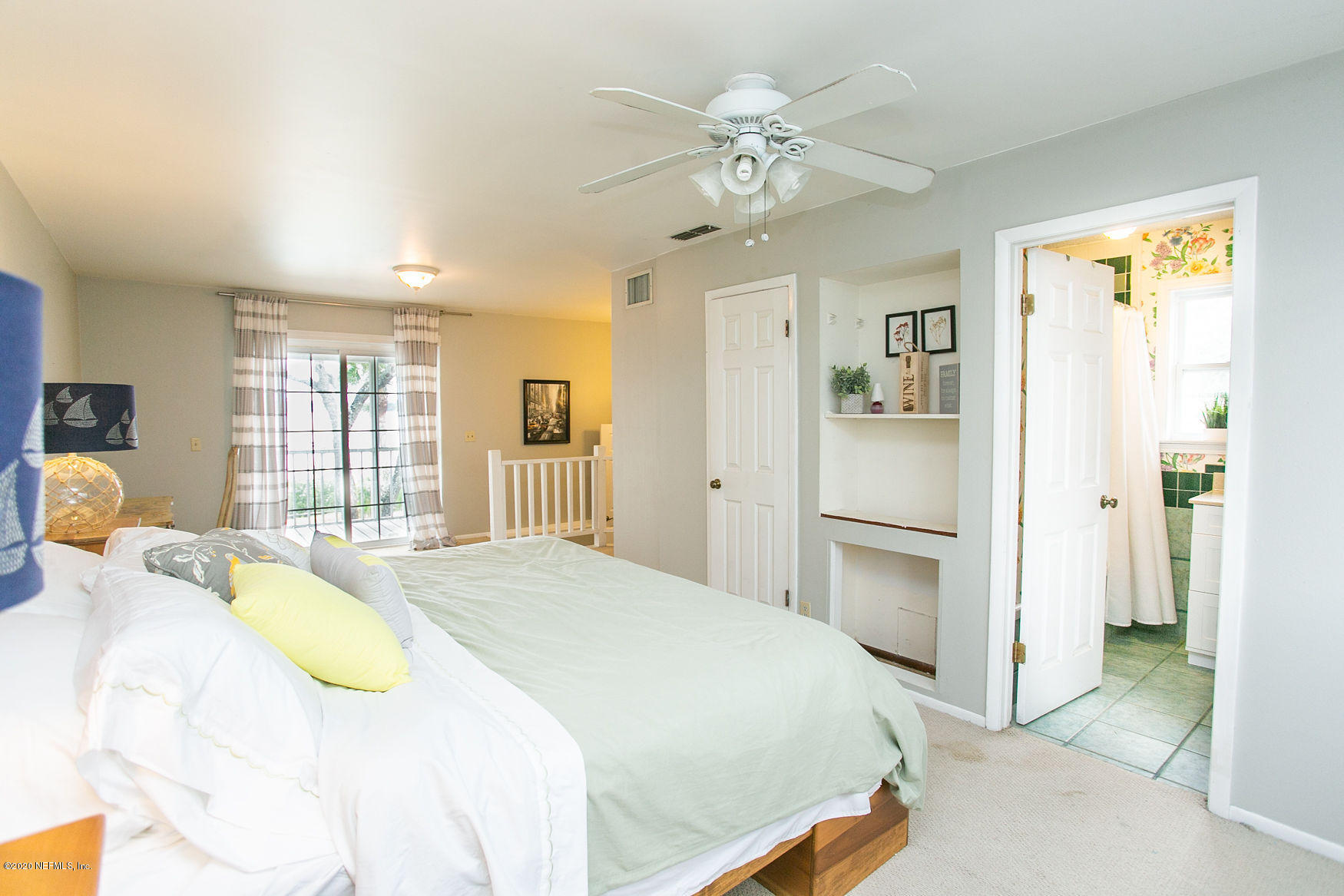 6317 Salado Road St. Augustine, FL 32080 - Photo 23 of 51 a spacious bedroom with a bed and a chandelier