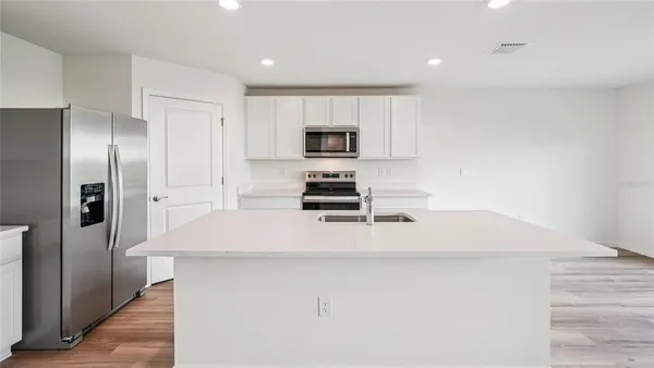 a kitchen with a refrigerator and a stove top oven