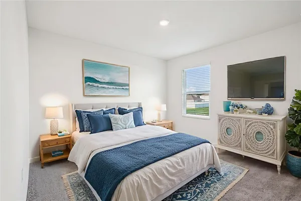 a bedroom with a bed and a flat tv screen on wall