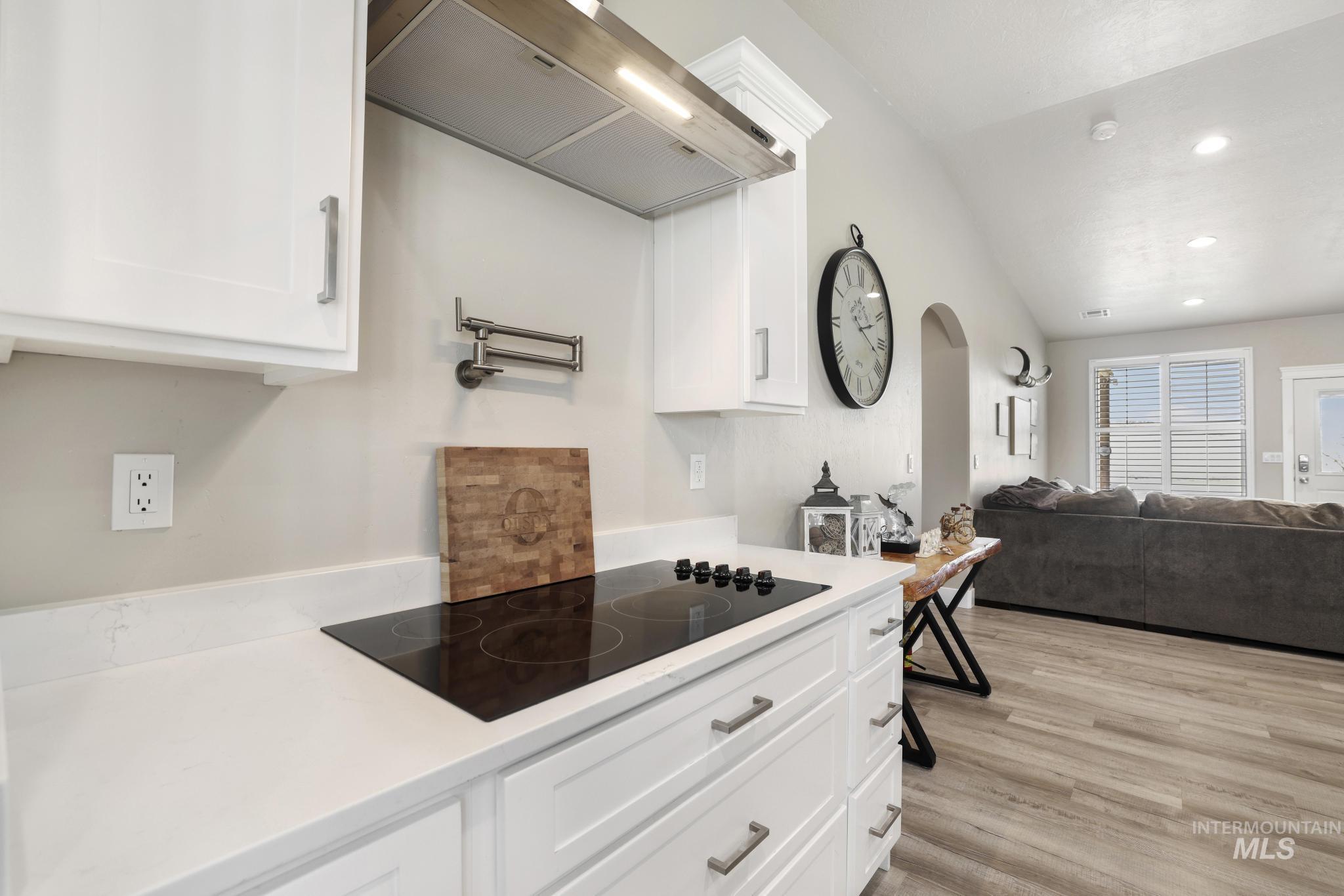 758 Cedar Crk Road Rogerson, ID 83302 - Photo 9 of 50 Kitchen featuring white cabinetry with silver hardware, an integrated cooktop, white countertops, and a pot filler