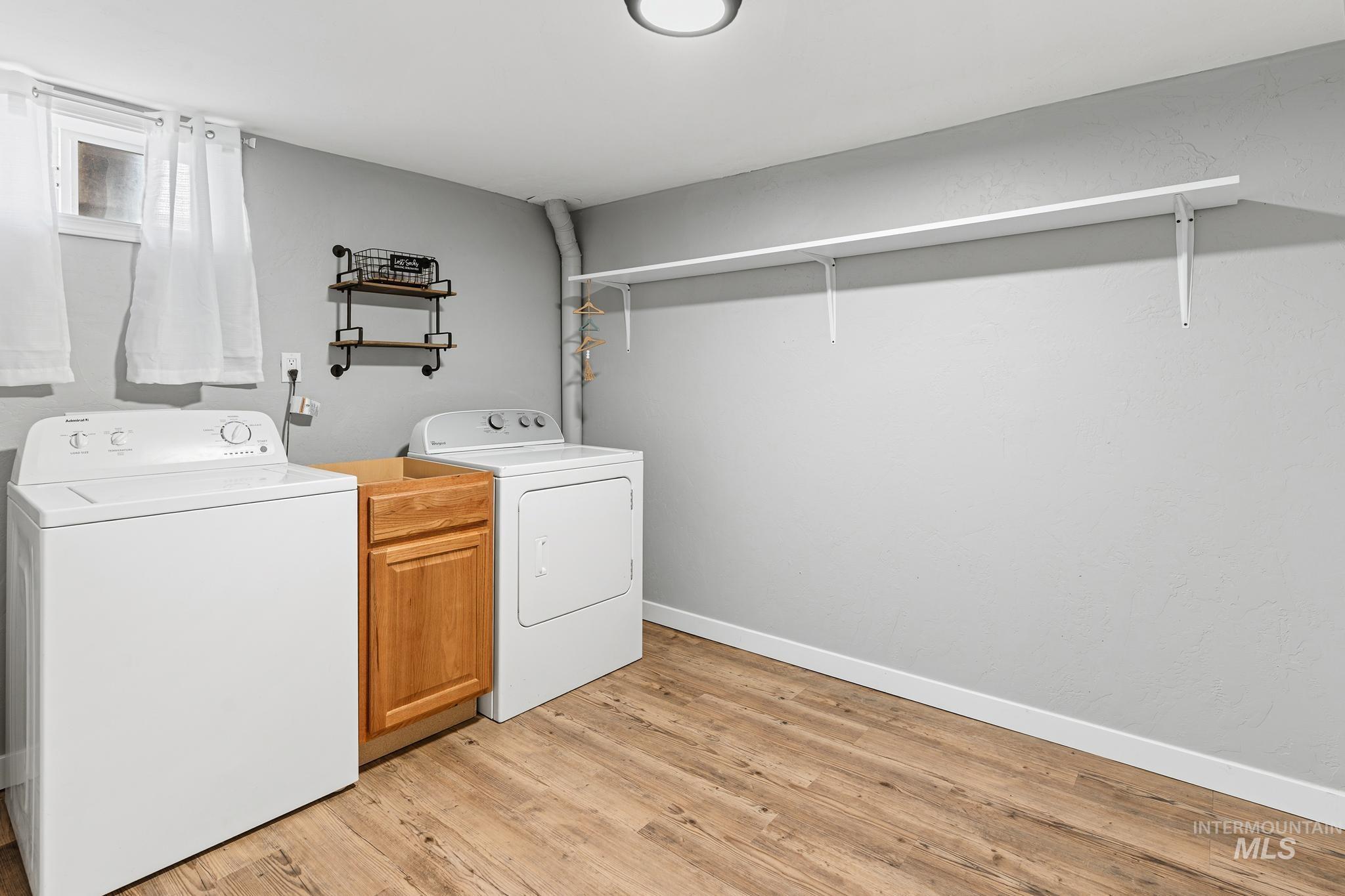 619 Thain Road Lewiston, ID 83501 - Photo 32 of 44 Dedicated laundry area featuring wood-finish flooring, light gray walls, and a built-in wood cabinet