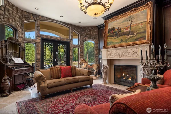 a living room with furniture a fireplace and a floor to ceiling window