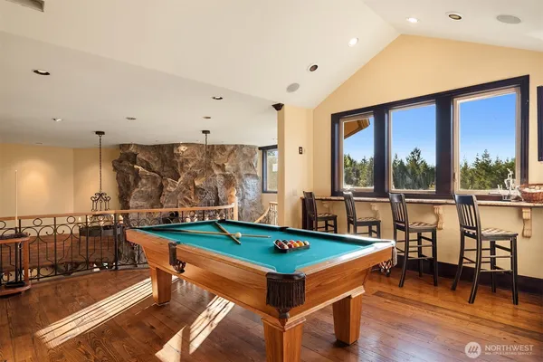 a living room with furniture pool table and a large window