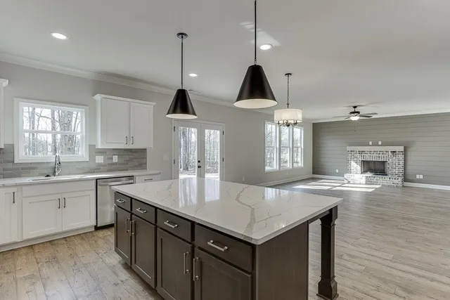 a kitchen with granite countertop a sink a center island and cabinets