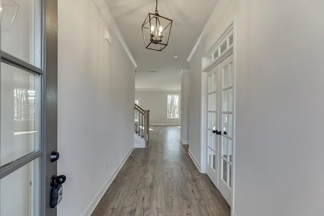 a view of a hallway with wooden floor and staircase