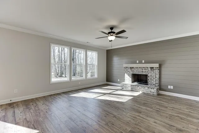 a view of an empty room with a fireplace and a window