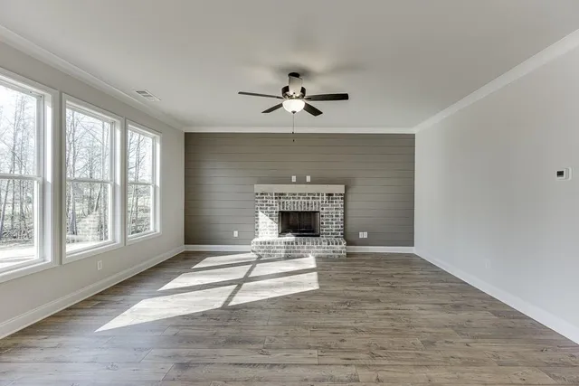 wooden floor fireplace and windows in an empty room