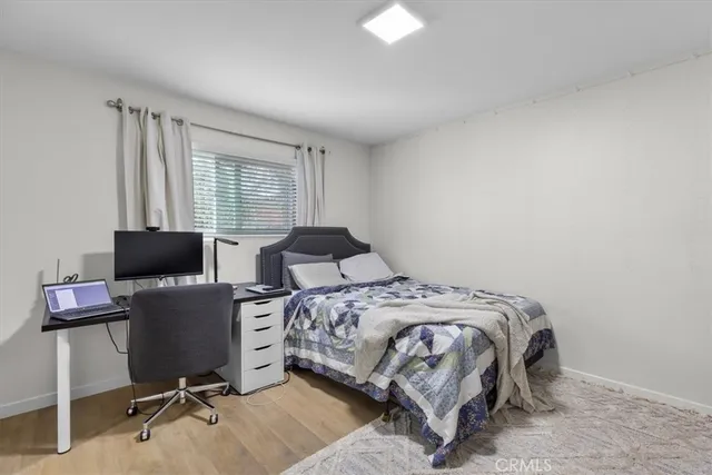 a bedroom with a bed and a computer on the desk