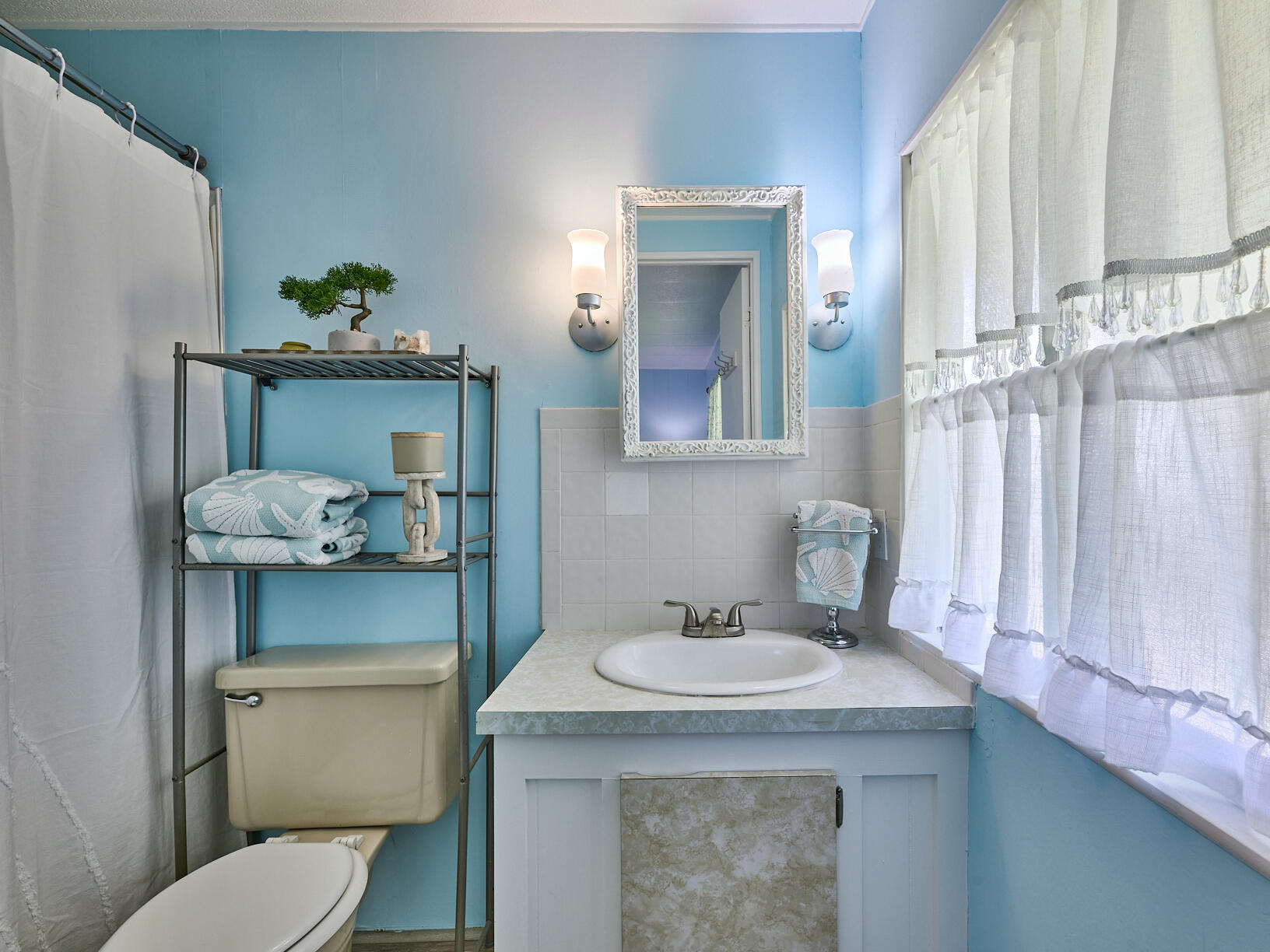 6977 Southeast Delegate Street Hobe Sound, FL 33455 - Photo 32 of 60 a bathroom with a toilet sink and mirror