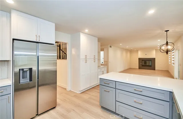 a kitchen with kitchen island a counter top space stainless steel appliances and a refrigerator