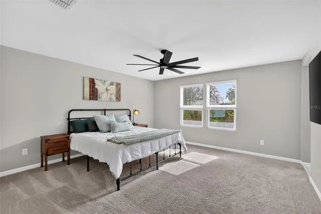 a bedroom with a large bed and a flat screen tv