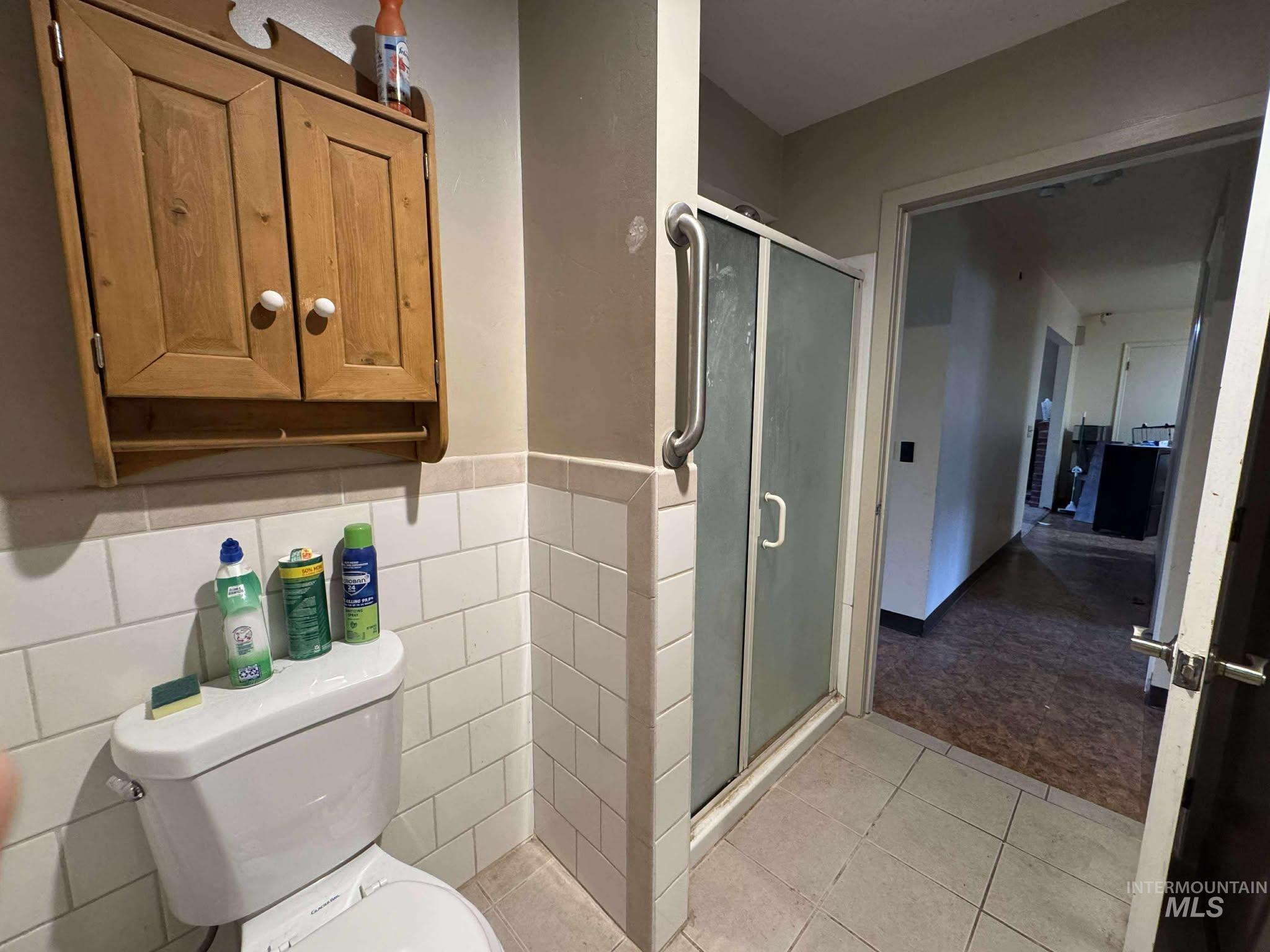 326 7th Street Lapwai, ID 83540 - Photo 4 of 5 Bathroom featuring a shower stall, light tile patterned flooring, and wainscoting