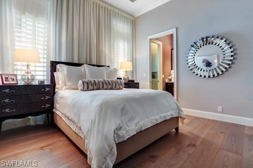 595 Regatta Road Naples, FL 34103 - Photo 26 of 40 Hardwood flooring throughout this room featuring crown molding, neutral wall tones, and a decorative wall mirror