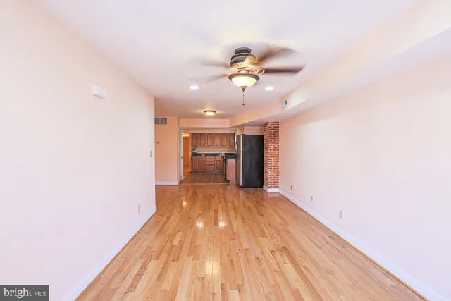 a view of empty room with wooden floor