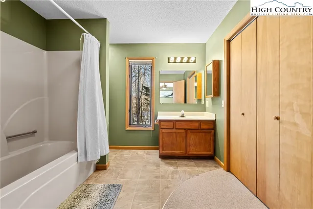 a bathroom with a granite countertop sink a mirror and a bathtub