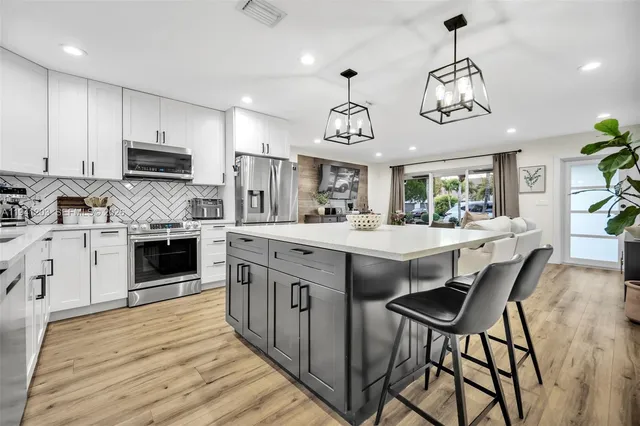 a kitchen with stainless steel appliances a stove a sink and a refrigerator