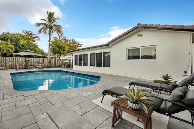 a view of a house with backyard swimming pool and sitting area