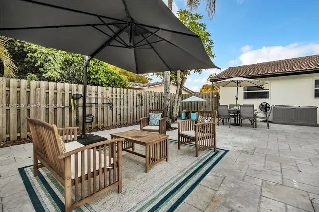 a view of a dining table and chairs under an umbrella
