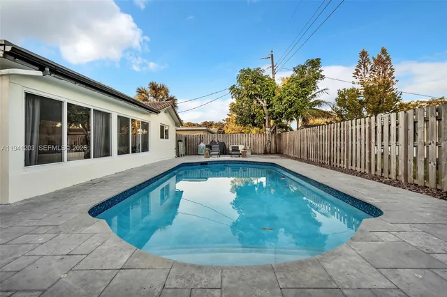 a view of a house with swimming pool and sitting area