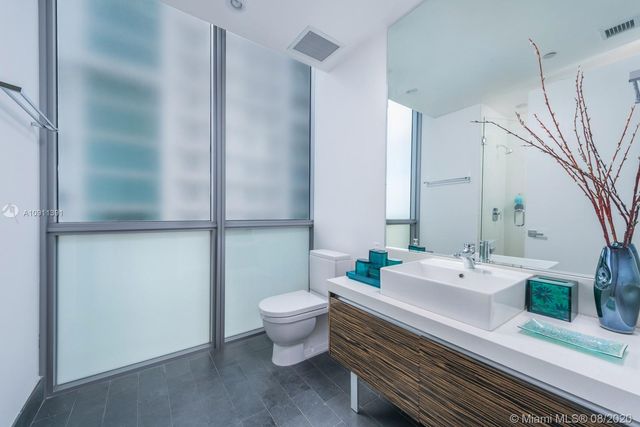 a bedroom with a large bed and a large window