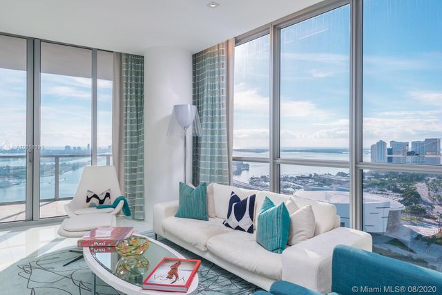 a living room with furniture and a floor to ceiling window