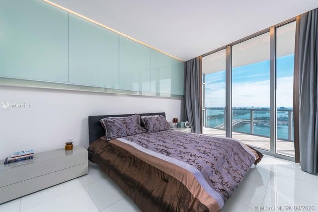 a bedroom with a large bed and a large window