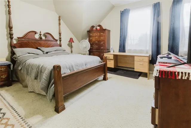 a spacious bedroom with a bed and a window