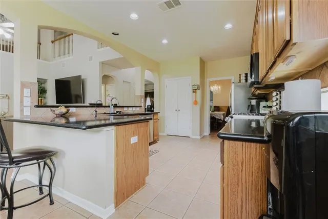 a kitchen with stainless steel appliances granite countertop a refrigerator a stove and a sink