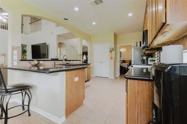 a kitchen with stainless steel appliances granite countertop a refrigerator a stove and a sink