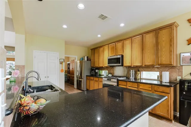 a kitchen with sink refrigerator and cabinets