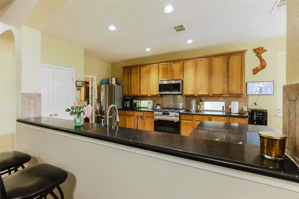 a kitchen with stainless steel appliances a sink a stove top oven a counter space and cabinets