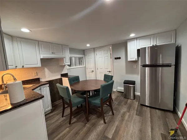 a kitchen with a refrigerator a table and chairs