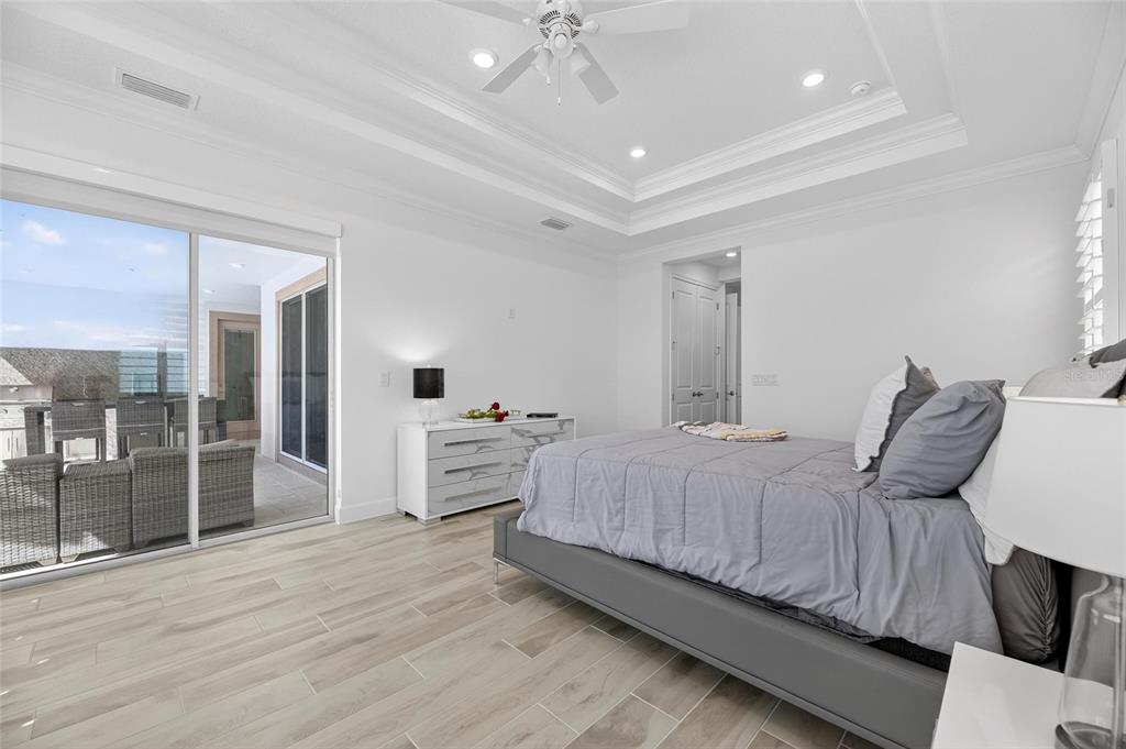 994 Signet Drive Apollo Beach, FL 33572 - Photo 32 of 98 a bedroom with a large bed and a chandelier