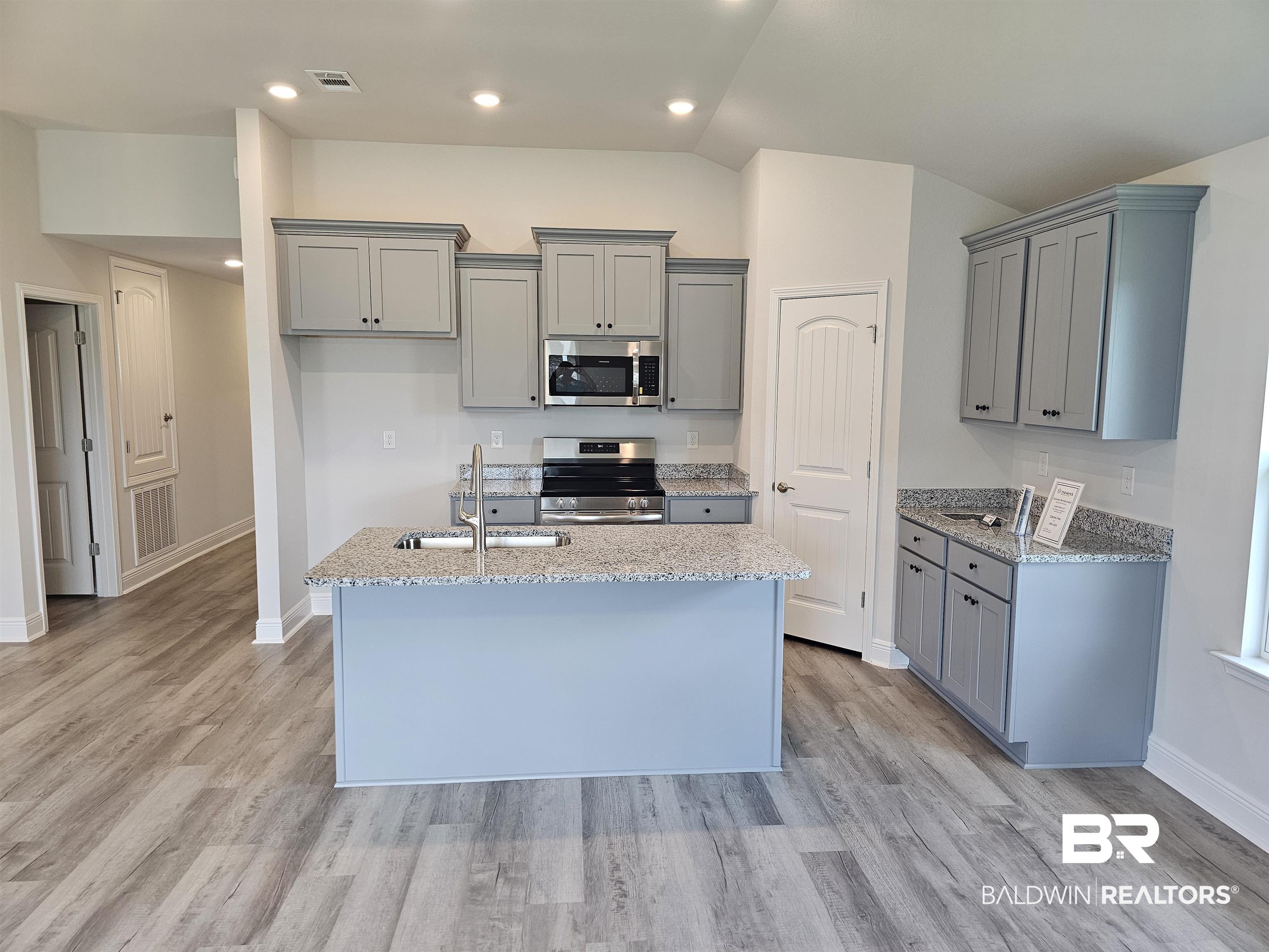 1412 Plymouth Drive Foley, AL 36535 - Photo 2 of 10 Kitchen featuring appliances with stainless steel finishes, a center island with sink, and light wood-type flooring