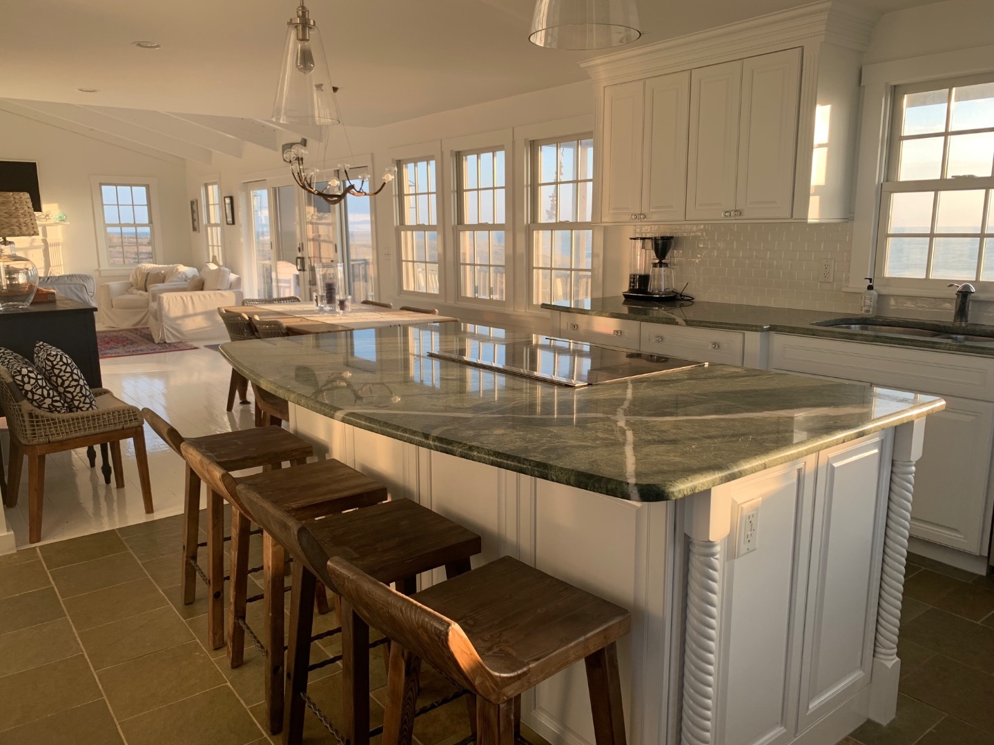 22 Sheep Pond Road Nantucket, MA 02554 - Photo 8 of 27 a kitchen with stainless steel appliances granite countertop a stove a sink a dining table and chairs with white cabinets