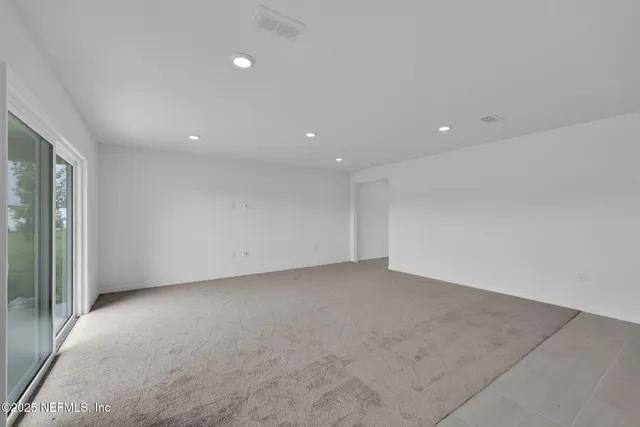 a spacious bedroom with a bed and a large window