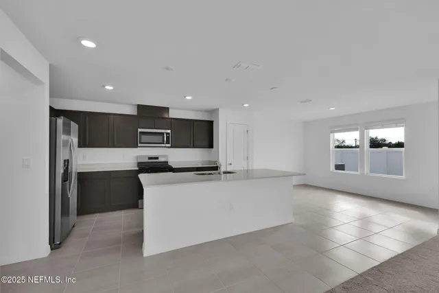 a view of kitchen with stainless steel appliances granite countertop refrigerator sink and stove