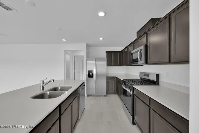 a view of kitchen with kitchen island white cabinets and stainless steel appliances