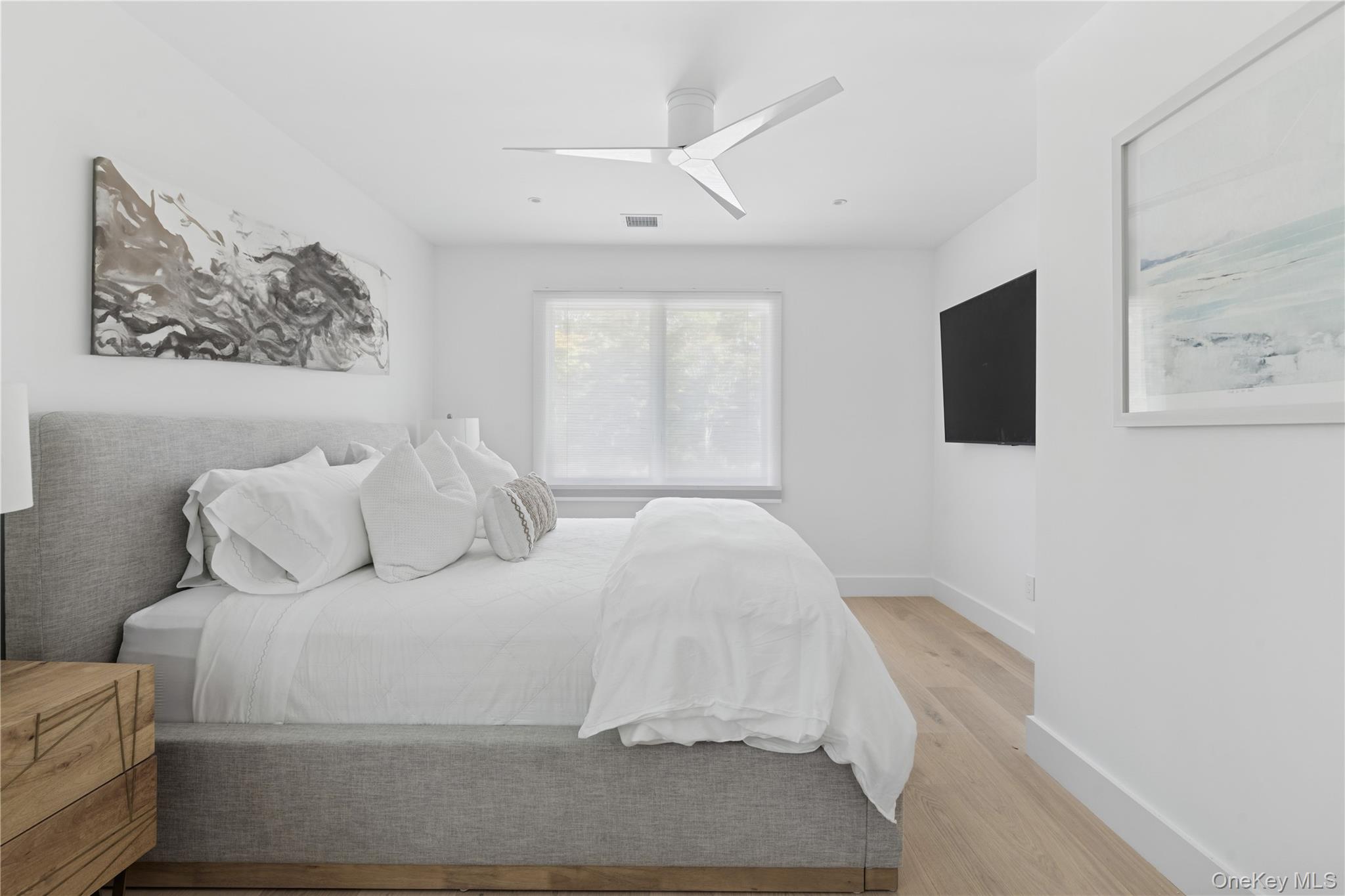 13 Sherwood Road Hampton Bays, NY 11946 - Photo 19 of 27 a bedroom with a bed and a flat screen tv
