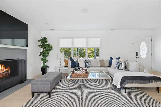 a living room with furniture a large window and a fireplace