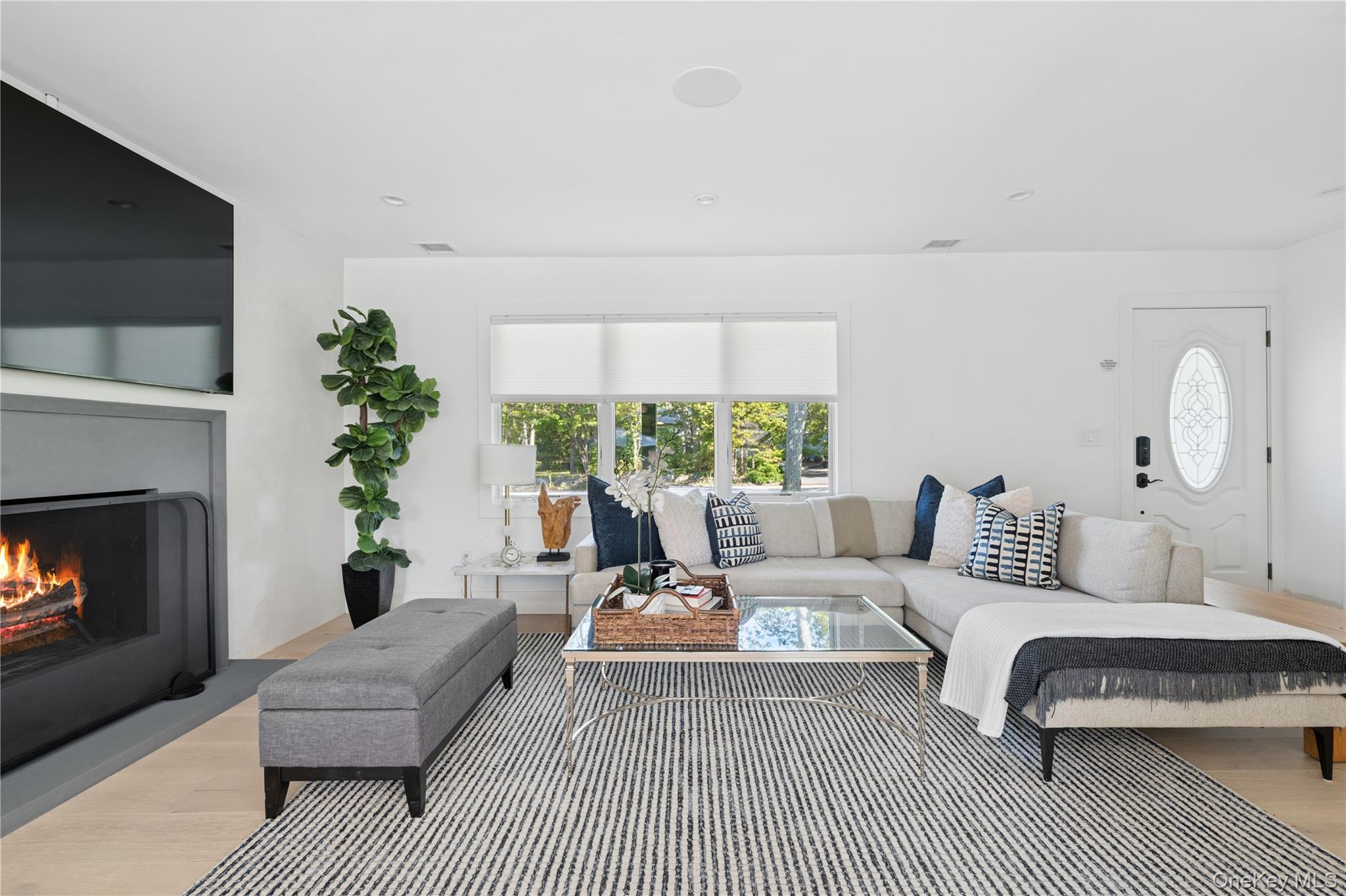 13 Sherwood Road Hampton Bays, NY 11946 - Photo 7 of 27 a living room with furniture a large window and a fireplace