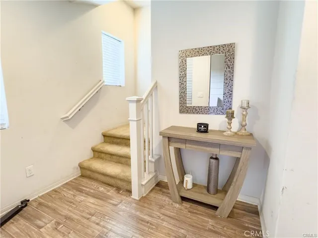 a view of front door with wooden floor and mirror